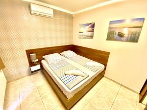 A bed or beds in a room at Unio Vendégház 1
