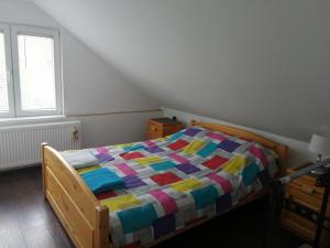 a bedroom with a wooden bed with a colorful quilt at Vikendica Lep pogled in Rtanj