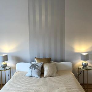 um quarto com uma cama branca e 2 candeeiros em Britannica em Hévíz