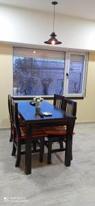 una mesa de comedor y sillas con una mesa azul y ventanas en Look Departamentos en Carhué