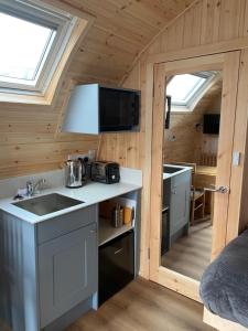 a kitchen in a tiny house with a sink at Mallaig Glamping Pods in Mallaig