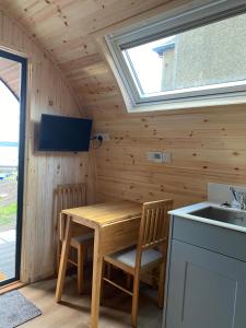 a small kitchen with a wooden table and a sink at Mallaig Glamping Pods in Mallaig