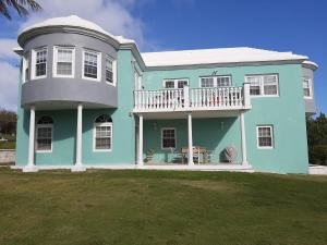 a blue house with a porch and a balcony at AIRBAB Moon Gate West in Mount Pleasant