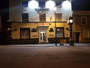 a building with a clock on the side of a street at The Vale Hotel in Cricklade