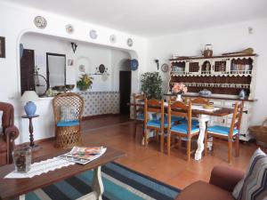 een woonkamer met een tafel en stoelen bij Villa El Alcazar in Carvoeiro