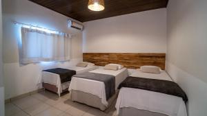 a room with three beds and a window at Santa Rosa Pantanal Hotel in Pôrto Jofre