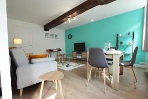 a living room with a couch and a table with chairs at Appartement centre de Valenciennes entièrement équipé 64m2 in Valenciennes