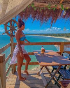 a woman in a bikini standing on the deck of a resort at Pousada Marambaia Café in Barra de Guaratiba