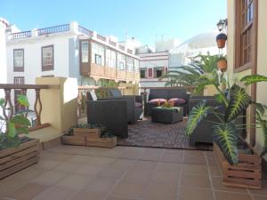 Un balcón con muebles y plantas en un edificio. en Casa Histórica San Sebastián, en Santa Cruz de la Palma