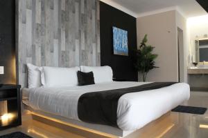 a bedroom with a large bed with white pillows at Motel Real de Queretaro in Querétaro