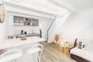 モンペリエにあるLoc'Apparts Montpellierのキッチン、白い壁と階段のあるリビングルーム