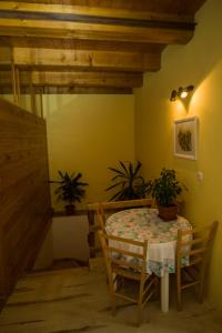 a dining room with a table and two potted plants at Rooms Roza in Slunj