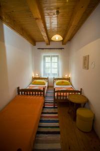 een kamer met vier bedden en een tafel erin bij Rooms Roza in Slunj