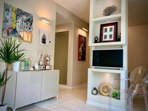 a living room with a tv and a white entertainment center at Villa Luminosa in Torre del Lago Puccini