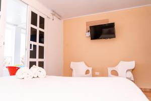 a bedroom with a bed and a tv on the wall at Summer Breeze in San Andrés