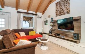 uma sala de estar com um sofá e uma televisão de ecrã plano em Holiday home Glavica em Postira