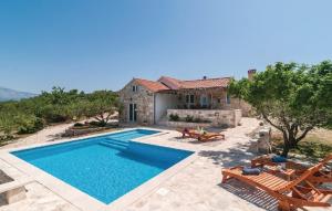 a villa with a swimming pool and a house at Holiday home Glavica in Postira