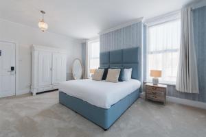a bedroom with a blue bed and a mirror at Somerset House Boutique Hotel and Restaurant in Portsmouth +39 photos