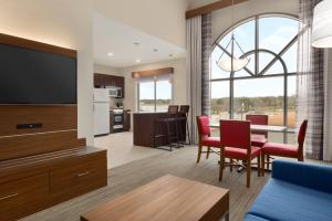 een woonkamer met een keuken en een eetkamer bij Holiday Inn Express Hotel & Suites Opelika Auburn, an IHG Hotel in Opelika