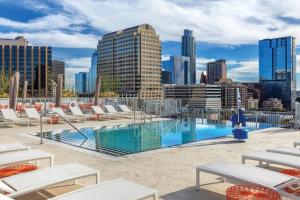 a swimming pool with lounge chairs and a city skyline at Club Wyndham Austin in Austin