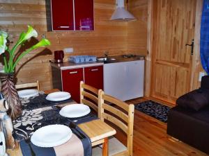 a kitchen and dining room with a table and chairs at Cozy Holiday Home in Mielno near Lake in Mielno