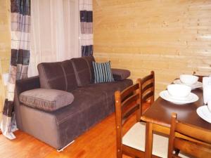 a living room with a couch and a table at Cozy Holiday Home in Mielno near Lake in Mielno