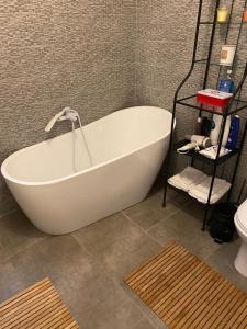 El baño incluye bañera blanca y aseo. en Casa Skadi, Zamora,Busteni en Buşteni