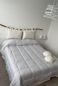 Appartamento Azzurro في فيرونا: سرير أبيض كبير في غرفة بيضاء بها