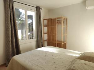 a bedroom with a bed and a window at La Ramade de Saint-Tropez in Saint-Tropez