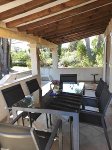 a patio with a table and chairs under a wooden roof at La Ramade de Saint-Tropez in Saint-Tropez
