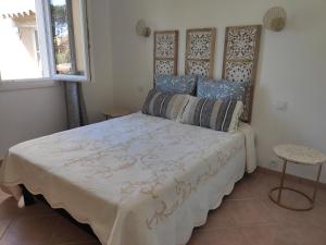 a bedroom with a large bed with blue pillows at La Ramade de Saint-Tropez in Saint-Tropez
