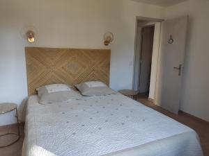 a bedroom with a large white bed with two pillows at La Ramade de Saint-Tropez in Saint-Tropez