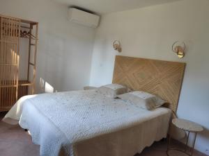 a bedroom with a bed with a white bedspread at La Ramade de Saint-Tropez in Saint-Tropez