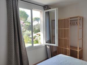 a bedroom with a window with a view of a yard at La Ramade de Saint-Tropez in Saint-Tropez