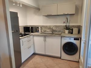 a kitchen with a sink and a washing machine at La Ramade de Saint-Tropez in Saint-Tropez