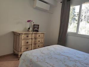 a bedroom with a dresser and a bed and a window at La Ramade de Saint-Tropez in Saint-Tropez