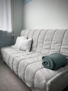 Appartamento Azzurro في فيرونا: أريكة بيضاء عليها وسادة خضراء