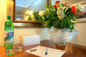 a bottle of wine and a vase of flowers on a table at Aaron Lodge in Edinburgh