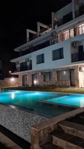 a building with a swimming pool at night at Вила Quiet Bay in Sozopol