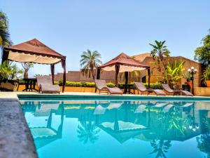 a swimming pool with chairs and a gazebo at Hotel San Luis Lindavista in Culiacán
