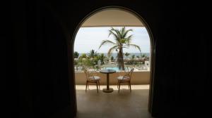 um quarto com uma mesa e cadeiras e uma palmeira em Loa Hotel em Tolú