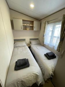 Giường trong phòng chung tại Tigers Wood - 2 bed hot tub lodge with free golf, NO BUGGY