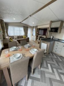 una cocina y comedor con una mesa en una caravana en Tigers Wood - 2 bed hot tub lodge with free golf, NO BUGGY, en Swarland