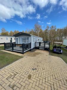 a home with a deck and a house at Tigers Wood - 2 bed hot tub lodge with free golf, NO BUGGY in Swarland