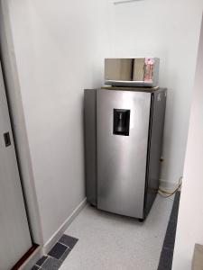 a small silver refrigerator in a corner of a room at La Habitación Perfecta in Barranquilla