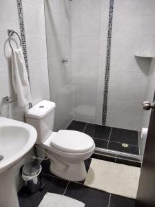 y baño con aseo, lavabo y ducha. en La Habitación Perfecta, en Barranquilla