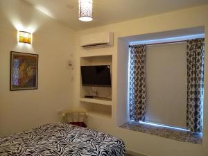a bedroom with a bed and a window and a television at La Habitación Perfecta in Barranquilla