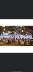 a group of people sitting at tables on the beach at LA DOLCE VITA - on the Beach - Samara in Sámara