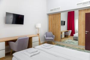 a hotel room with a bed and a mirror at H11 Downtown Apartments in Târgu-Mureş