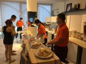 里米尼的住宿－依賽德凱達酒店，一群人在厨房准备食物
